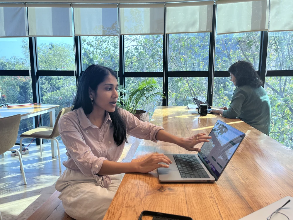 Kajal Jain working on a laptop at a shared table